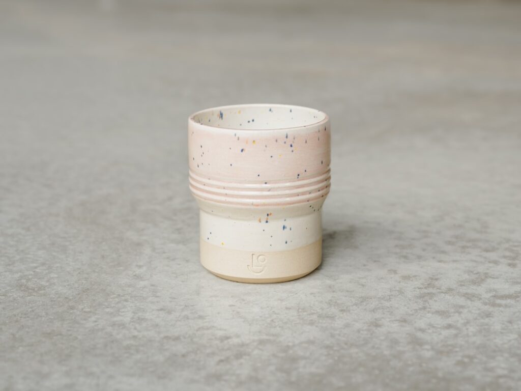 a white cup on a grey surface