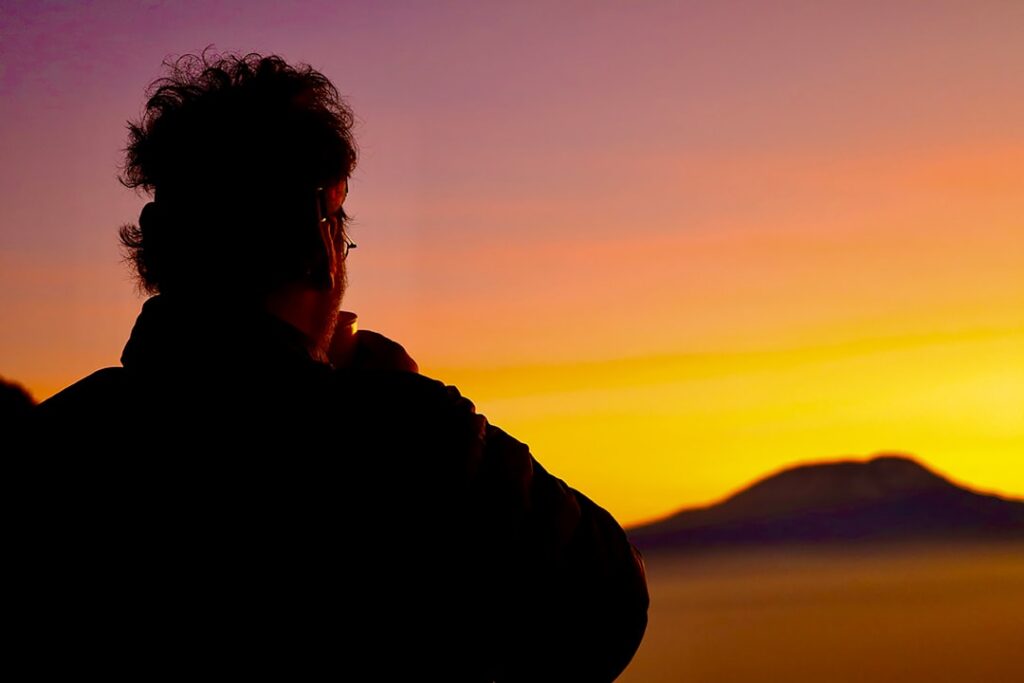 A person standing in front of a sunset