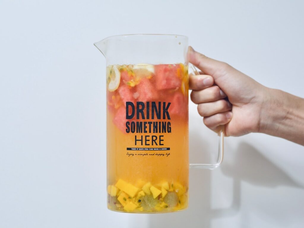 a person is holding a pitcher of drink