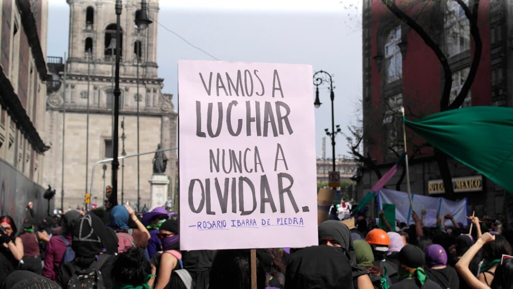 Protest sign reads: "we will fight, never forget."