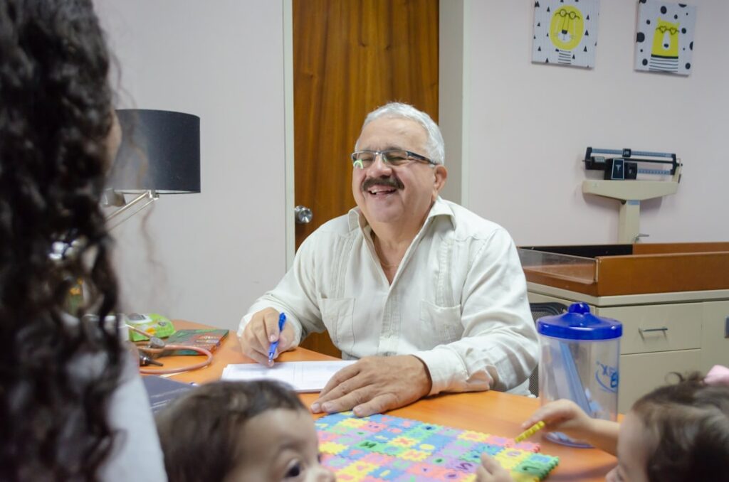 a man sitting at a table with a group of children