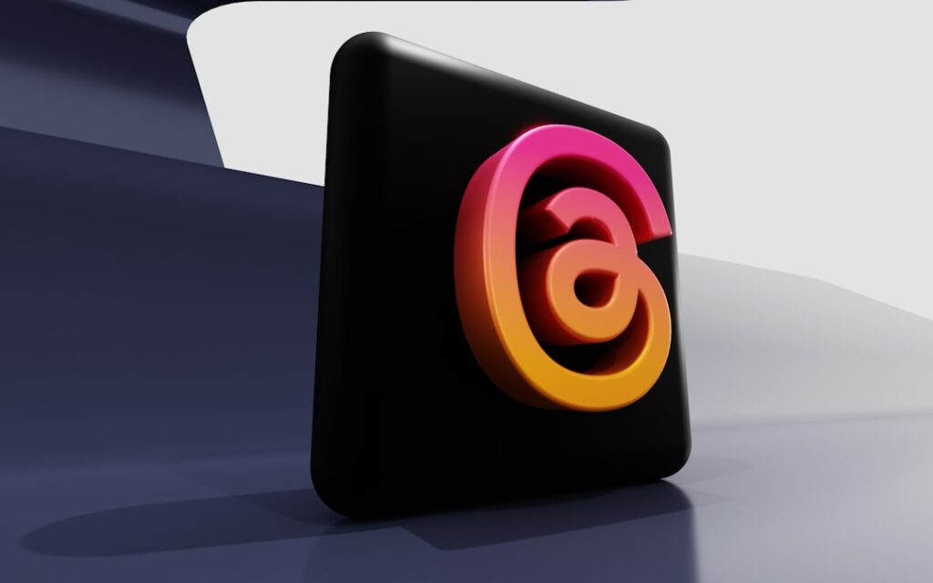 a black square with a pink and yellow logo