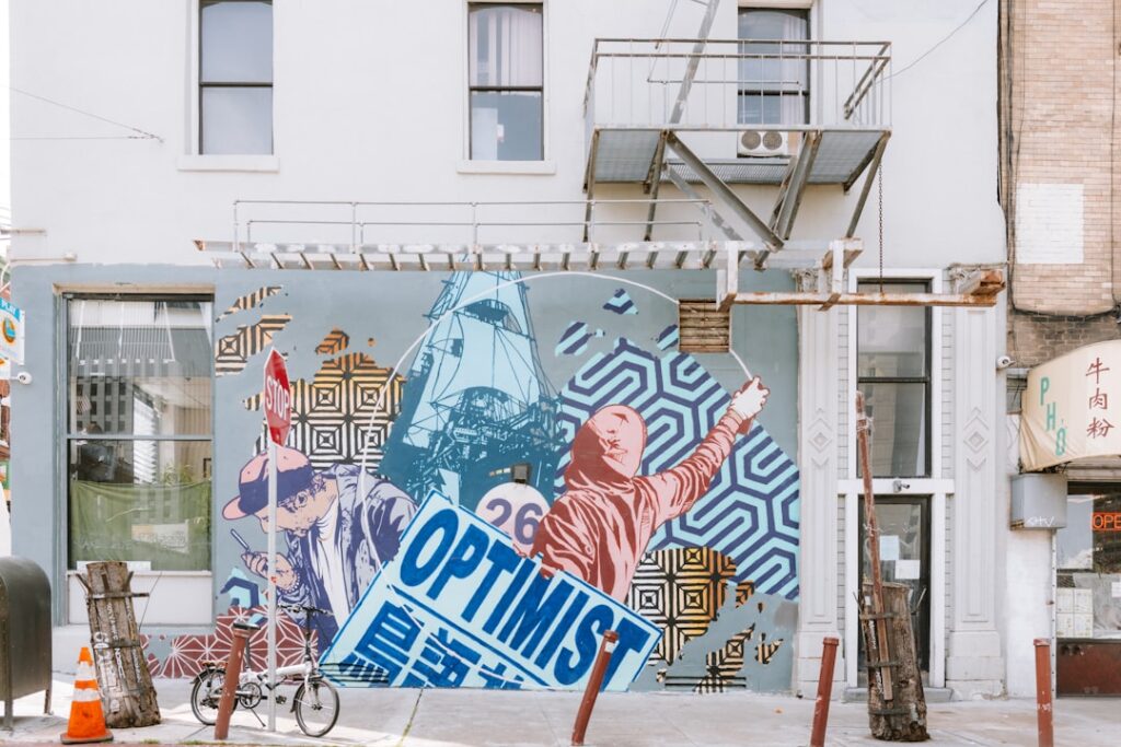 A street mural displays the word "optimist".