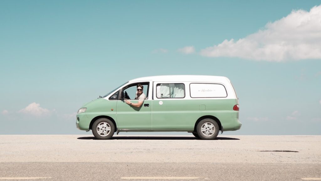 Man driving a mint green van on a sunny day