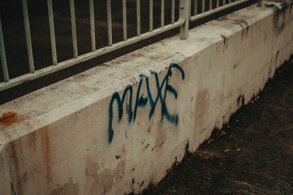 a concrete wall with blue graffiti on it