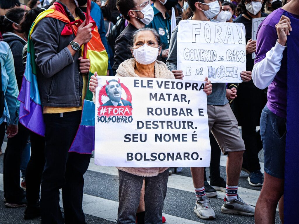 a group of people holding signs and wearing masks